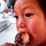 M enjoys a drumstick of Waukau Chicken.